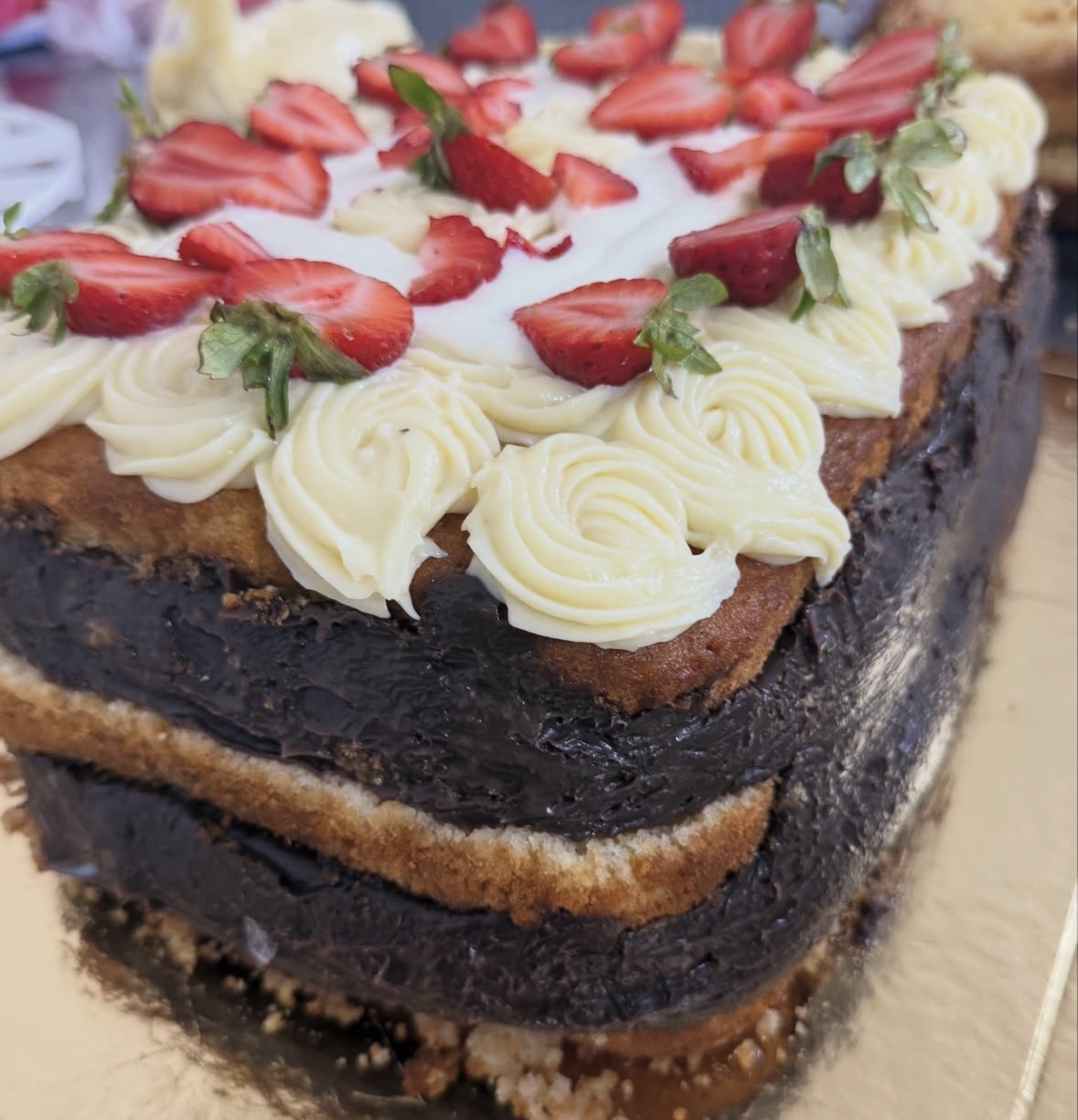 Bolo de chocolate com morangos e rosetas de creme